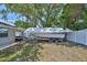 Backyard featuring a covered boat on a trailer, partially shaded by a mature tree at 540 Firefly Ln, Apollo Beach, FL 33572