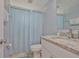 Bathroom featuring light blue walls, a granite countertop, and a blue shower curtain at 540 Firefly Ln, Apollo Beach, FL 33572