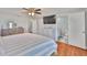 Bedroom featuring a dresser, TV, and a doorway to the bathroom with wood-look floors at 540 Firefly Ln, Apollo Beach, FL 33572