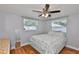 Cozy bedroom featuring wood-look floors, a ceiling fan, and two bright windows at 540 Firefly Ln, Apollo Beach, FL 33572