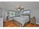 Comfortable bedroom features a ceiling fan, two windows, and hardwood floors at 540 Firefly Ln, Apollo Beach, FL 33572
