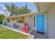Close-up showcasing a light-colored exterior with wooden shutters and a vibrant blue front door at 540 Firefly Ln, Apollo Beach, FL 33572