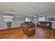 Spacious living room with wood floors, comfortable leather seating, and natural light from multiple windows at 540 Firefly Ln, Apollo Beach, FL 33572