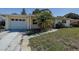 View of the home's exterior, driveway, and front yard with mature trees at 5483 37Th N Ave, St Petersburg, FL 33710