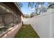 Narrow backyard area enclosed by a white vinyl fence, with a screened-in porch visible at 5533 Golden Nugget Dr, Holiday, FL 34690