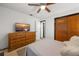 Bedroom features a ceiling fan, dresser with TV, and closet at 5533 Golden Nugget Dr, Holiday, FL 34690