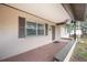 Inviting front porch with brick flooring and hanging plants at 5533 Golden Nugget Dr, Holiday, FL 34690