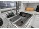 Close-up of a stainless-steel kitchen sink with white cabinets and granite countertops at 5533 Golden Nugget Dr, Holiday, FL 34690