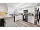 Bright kitchen featuring white cabinets, modern appliances, and wood-look flooring at 5533 Golden Nugget Dr, Holiday, FL 34690