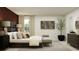 Well-lit bedroom with modern decor, a comfortable bed, and a seating bench at 5676 Red Kite Dr, Wimauma, FL 33598