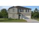 Two-story home boasts a modern exterior with gray siding and a two-car garage at 5676 Red Kite Dr, Wimauma, FL 33598