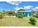 A charming backyard with a turquoise house, green grass and well-kept landscaping at 6195 28Th N Ave, St Petersburg, FL 33710