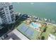 An aerial view featuring a tennis court, swimming pool, marina, and luxury waterfront condos at 660 Island Way #206 # 206, Clearwater, FL 33767