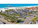 Aerial view of a beach parking lot with cars, palm trees, and a pier in the background at 660 Island Way #206 # 206, Clearwater, FL 33767