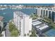 An aerial view of a condo building with tennis court, pool, parking, and marina in a coastal setting at 660 Island Way #206 # 206, Clearwater, FL 33767