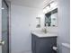 Bathroom featuring a gray vanity with white countertop, decorative mirror, and a standing shower at 660 Island Way #206 # 206, Clearwater, FL 33767