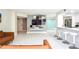 Open-concept living area with marble floors, entertainment center, and bar seating at 660 Island Way #206 # 206, Clearwater, FL 33767