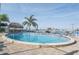 Outdoor community pool area with lounge chairs and tiki hut at 660 Island Way #206 # 206, Clearwater, FL 33767