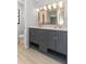 Double sink bathroom vanity with large mirror and grey cabinets at 7322 Ellis Ln, Port Charlotte, FL 33981