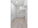Bright laundry room with overhead storage cabinets, wood flooring, and closet at 7322 Ellis Ln, Port Charlotte, FL 33981