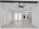 Bright living room with wood floors, ceiling fan, and view into the kitchen at 7322 Ellis Ln, Port Charlotte, FL 33981