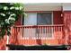 Close up of a red balcony with white framed sliding glass doors and a partial view of foliage at 8220 12Th N Way # H, St Petersburg, FL 33702