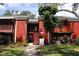 Two-story red brick building with well-maintained landscaping and stairs leading to second-floor units at 8220 12Th N Way # H, St Petersburg, FL 33702