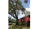 Exterior view of a red brick building with balconies, surrounded by lush greenery and mature trees at 8220 12Th N Way # H, St Petersburg, FL 33702