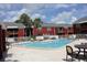 Community pool surrounded by lounge chairs and a white fence, offering a relaxing outdoor space at 8220 12Th N Way # H, St Petersburg, FL 33702