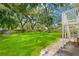 Lush backyard with green grass, mature trees, and a fenced perimeter, creating a private outdoor space at 859 Harbor Hill Dr, Safety Harbor, FL 34695