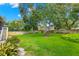 Spacious backyard featuring lush green grass, mature trees, and a wooden fence for privacy at 859 Harbor Hill Dr, Safety Harbor, FL 34695