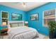 Bright bedroom featuring blue walls, white bedding, stylish decor, and natural light from two windows at 859 Harbor Hill Dr, Safety Harbor, FL 34695