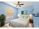 Cozy bedroom features light blue walls, white bedding, and natural light from a window at 859 Harbor Hill Dr, Safety Harbor, FL 34695
