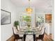 Bright dining room with modern chandelier, a glass table with seating for eight, and wood flooring at 859 Harbor Hill Dr, Safety Harbor, FL 34695