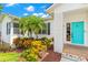 Close up of home's entrance highlighting the turquoise door, surrounding plants and brick pillar at 859 Harbor Hill Dr, Safety Harbor, FL 34695