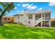 Back of the house featuring white siding, a screened porch, and a well-maintained lawn at 859 Harbor Hill Dr, Safety Harbor, FL 34695