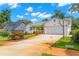 Exterior home view showcasing a driveway with basketball hoop, lawn with garden bed, and nearby houses at 859 Harbor Hill Dr, Safety Harbor, FL 34695