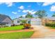 Charming single-story home with well-manicured lawn, a vibrant turquoise door and an attached garage at 859 Harbor Hill Dr, Safety Harbor, FL 34695