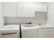Well-organized laundry room with washer, dryer, sink, and ample storage cabinets at 859 Harbor Hill Dr, Safety Harbor, FL 34695