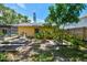 A sunny backyard featuring unique landscaping with stone garden beds and a mature tree at 859 Patterson Dr, Sarasota, FL 34234