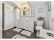 Bathroom with double vanity, patterned wallpaper, and plush rugs at 859 Patterson Dr, Sarasota, FL 34234