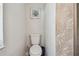 Powder room features neutral paint, tropical art, and palm wallpaper at 859 Patterson Dr, Sarasota, FL 34234