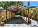 View of the covered carport with gravel surface, adjacent to wooden privacy fence and yellow exterior of the home at 859 Patterson Dr, Sarasota, FL 34234