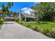 Single-Gathering home with a screened porch, a long driveway, a two car garage, and lush landscaping at 859 Patterson Dr, Sarasota, FL 34234