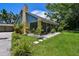 Home featuring a screened porch, a long driveway, mature trees, and meticulous landscaping that adds beauty at 859 Patterson Dr, Sarasota, FL 34234