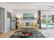 Living room with comfortable seating, tile floors, view of pool, and a modern refrigerator at 859 Patterson Dr, Sarasota, FL 34234