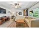 Comfortable living room with a sectional sofa, area rug, wooden entertainment center and lots of natural light at 859 Patterson Dr, Sarasota, FL 34234
