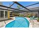 Lovely in-ground pool surrounded by brick patio and screened enclosure that creates a private outdoor retreat at 859 Patterson Dr, Sarasota, FL 34234