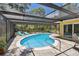 Enjoy the in-ground pool surrounded by a screened enclosure, patio, and vibrant landscaping, perfect for outdoor relaxation at 859 Patterson Dr, Sarasota, FL 34234