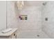 Walk-in shower featuring white marble-style tile and mosaic tile flooring at 859 Patterson Dr, Sarasota, FL 34234